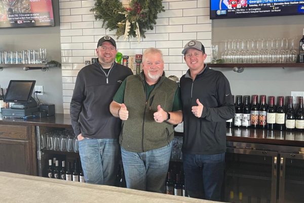 Local Tap owners behind the bar offering thumbs up